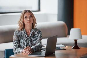 It's your personal psychologist. Businesswoman with curly blonde hair sitting in room against window photo