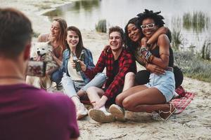 Love is in the air. Group of people have picnic on the beach. Friends have fun at weekend time photo