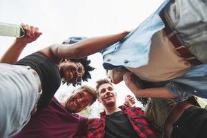 With alcohol. Multi ethnic group of people have party outdoors. View from down photo