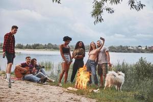 Warm summer. Group of people have picnic on the beach. Friends have fun at weekend time photo