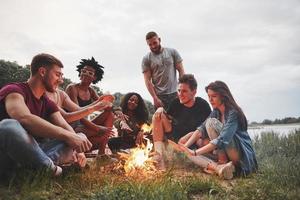 fiesta de verano en la playa. grupo de personas tienen picnic. los amigos se divierten el fin de semana foto