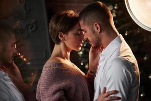 baile romantico cercanía del chico y la chica en ropa de lujo que bailan y coquetean. hermosa reflexión desde el lado foto