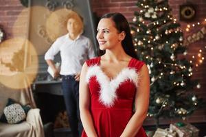 Surprise time. Woman in red dress will now receive Christmas gift from boyfriend photo