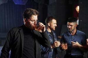 People have fun in the night club. With alcohol in hands photo