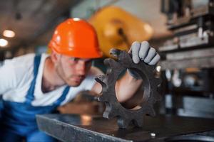 todo debe ser perfecto. hombre en uniforme trabaja en la producción. tecnología industrial moderna foto