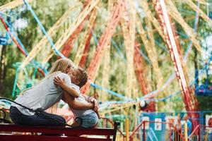 Embracing each other. Cheerful little girl her mother have a good time in the park together near attractions photo