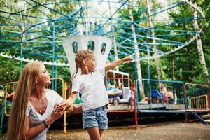 Loving each other. Cheerful little girl her mother have a good time in the park together near attractions photo