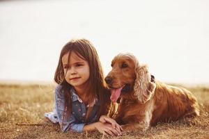 Warm and quiet. Cute little girl have a walk with her dog outdoors at sunny day photo