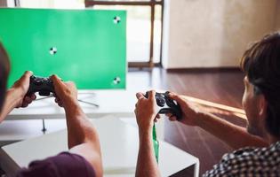 Group of friends have fun playing console game indoors at living room photo