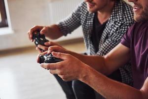 Group of friends have fun playing console game indoors at living room photo