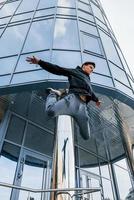 joven haciendo parkour en la ciudad durante el día. concepción de los deportes extremos foto