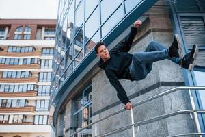 joven haciendo parkour en la ciudad durante el día. concepción de los deportes extremos foto