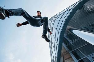 joven haciendo parkour en la ciudad durante el día. concepción de los deportes extremos foto