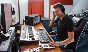 ingeniero de sonido en auriculares trabajando y mezclando música en interiores en el estudio foto