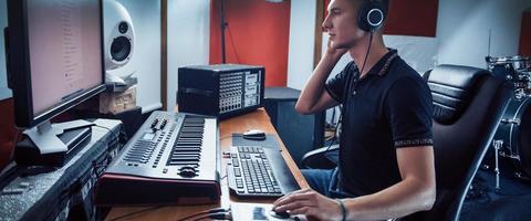 ingeniero de sonido en auriculares trabajando y mezclando música en interiores en el estudio foto