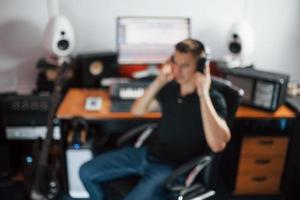 ingeniero de sonido en auriculares trabajando y mezclando música en interiores en el estudio foto