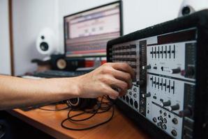 Using the mixer. Sound engineer working indoors in the studio photo