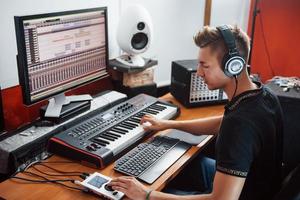 ingeniero de sonido en auriculares trabajando y mezclando música en interiores en el estudio foto