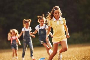 Through obstacles. Kids running in the field at sunny day. Conception of healthy lifestyle photo