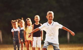 niños corriendo en el campo en un día soleado. concepto de estilo de vida saludable foto