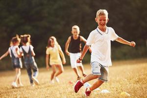 a través de obstáculos. niños corriendo en el campo en un día soleado. concepto de estilo de vida saludable foto