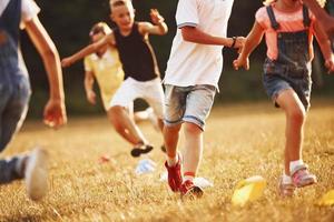 Through obstacles. Kids running in the field at sunny day. Conception of healthy lifestyle photo