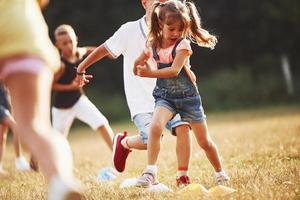 Through obstacles. Kids running in the field at sunny day. Conception of healthy lifestyle photo