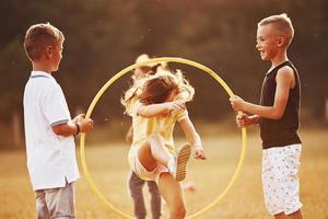 saltando a través de la herramienta de fitness circular. niños divirtiéndose en el campo foto