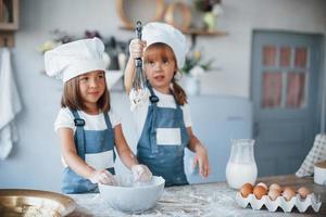 Family kids in white chef uniform preparing food on the kitchen photo