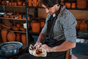 Handsome ceramist packages his fresh product in the paper photo