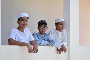 Young southeast asian children standing in a row in front of balcony and waiting to do their daily activity, soft and selective focus. photo