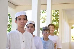 Young southeast asian children standing in a row in front of balcony and waiting to do their daily activity, soft and selective focus. photo