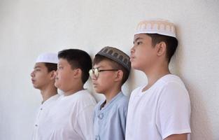 niños jóvenes del sudeste asiático parados en fila frente al balcón y esperando para hacer su actividad diaria, enfoque suave y selectivo. foto