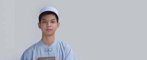 Portrait Young asian muslim boy smilling and standing in front of his classroom, soft and selective focus. photo