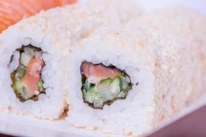 Japanese food rolls in sesame with salmon, cucumber, Philadelphia cheese. Food delivery. photo