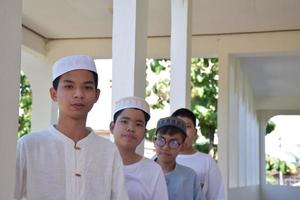 Young southeast asian children standing in a row in front of balcony and waiting to do their daily activity, soft and selective focus. photo