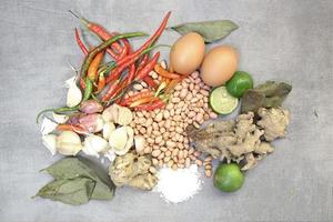 a collection of spices, chilies, onions, nuts and various kinds on a concrete background photo