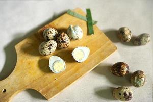 sliced quail eggs on a cutting board on a white background photo