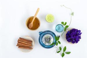 vista superior del té de flor de guisante de mariposa con limones sobre fondo blanco. concepto de bebida saludable. foto