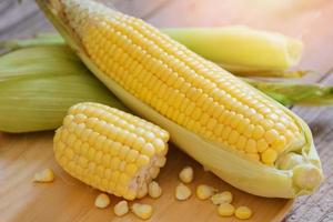 maíz fresco sobre fondo de madera, cosecha de maíz maduro orgánico, maíz en la mazorca, maíz dulce para cocinar alimentos foto