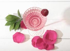 una copa de delicado vino de fresa con bayas y pétalos de rosa. vista superior foto