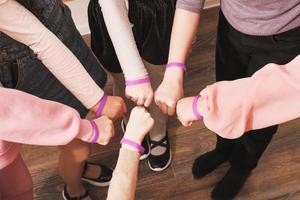 manos de niñas con las mismas pulseras, trabajo en equipo, cooperación, apoyo y trabajo en equipo. concepto de unidad y unión.