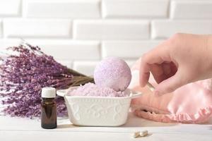 hand holding Melatonin capsules. Relaxing bath salt and bath bomb with lavender oil. Lavender as calming and soothing ingredient for good sleep. insomnia support. photo