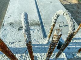 the concrete slab is covered with gray paint. old, rusty rebar sticks out of the material. erection of high, multi-storey buildings photo