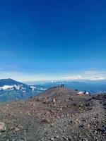 the view above the cloud tops of Mount Marapi, West Sumatra, with a bright blue sky as a background photo