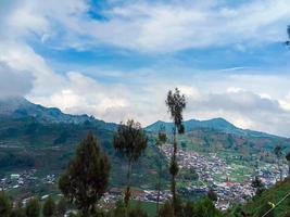 the village in the middle of the potato fields seen from the top of the hill in the Dieng plateau area photo