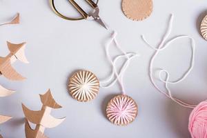 DIY Christmas handmade decorations made of cardboard and yarn on the table. Top view. Closeup photo