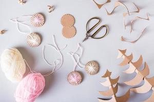 DIY Christmas handmade decorations made of cardboard and yarn on the table. Top view. photo