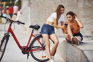 dos mujeres jóvenes con bicicleta se divierten en el parque cerca de la rampa foto