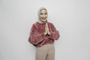 Portrait of a young beautiful Asian Muslim woman wearing a hijab gesturing Eid Mubarak greeting photo